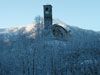 La chiesa parrocchiale di Viu' spunta dagli alberi innevati